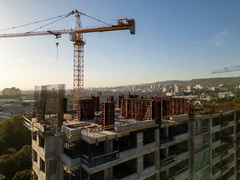 A drone video capturing the construction site of a high-rise building at sunset. The structure's